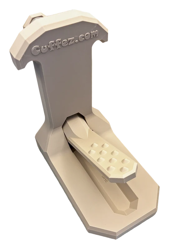Cuffez in Sand, seen from a three-quarter angle: a flat base, an upright post with a T-shaped head, and the pedal arm folded closed.